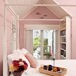 a bedroom with a white bed, pink walls and a matching sloping ceiling is such a cozy sleeping space
