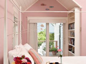 a bedroom with a white bed, pink walls and a matching sloping ceiling is such a cozy sleeping space
