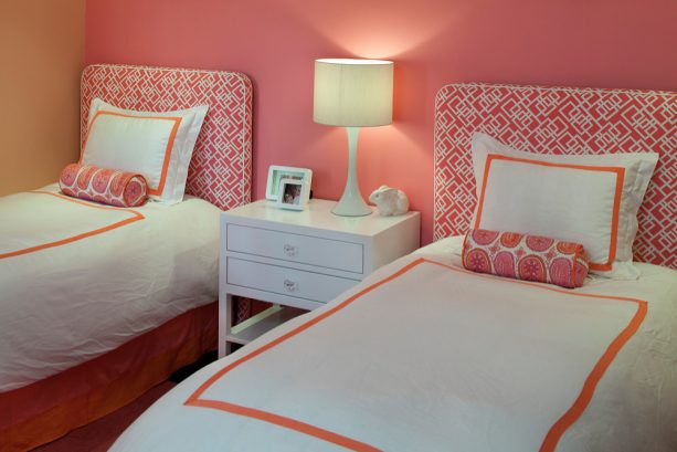 create a serene bedroom with a rosy blush wall and matching pink headboards on white beds