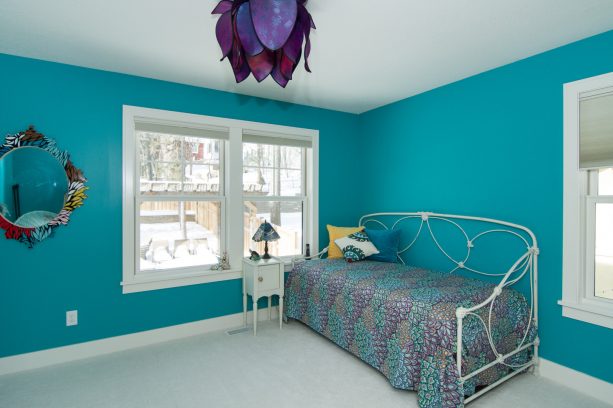 teal walls and an artistic purple lamp cover create a stunning craftsman bedroom