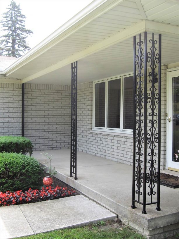 black wrought iron columns are perfect for a traditional concrete porch