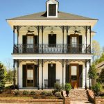 lanky wrought iron columns add a pleasant look to the porch of a two-story house