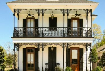 lanky wrought iron columns add a pleasant look to the porch of a two-story house