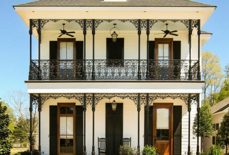 lanky wrought iron columns add a pleasant look to the porch of a two-story house