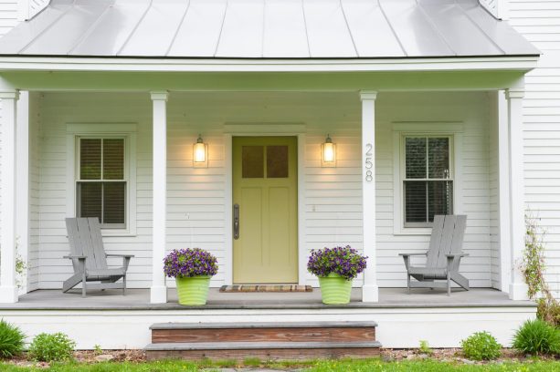 a benjamin moore’s agave green front door is watching over a porch with trex decking