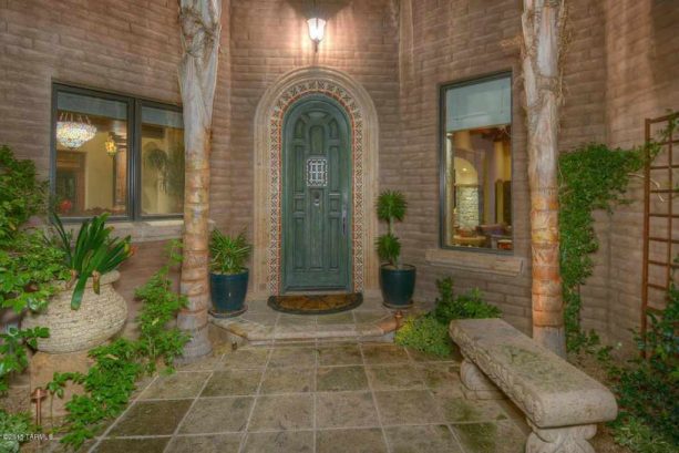 a green front door surrounded by benjamin moores dellwood sand walls creates a serene and peaceful atmosphere