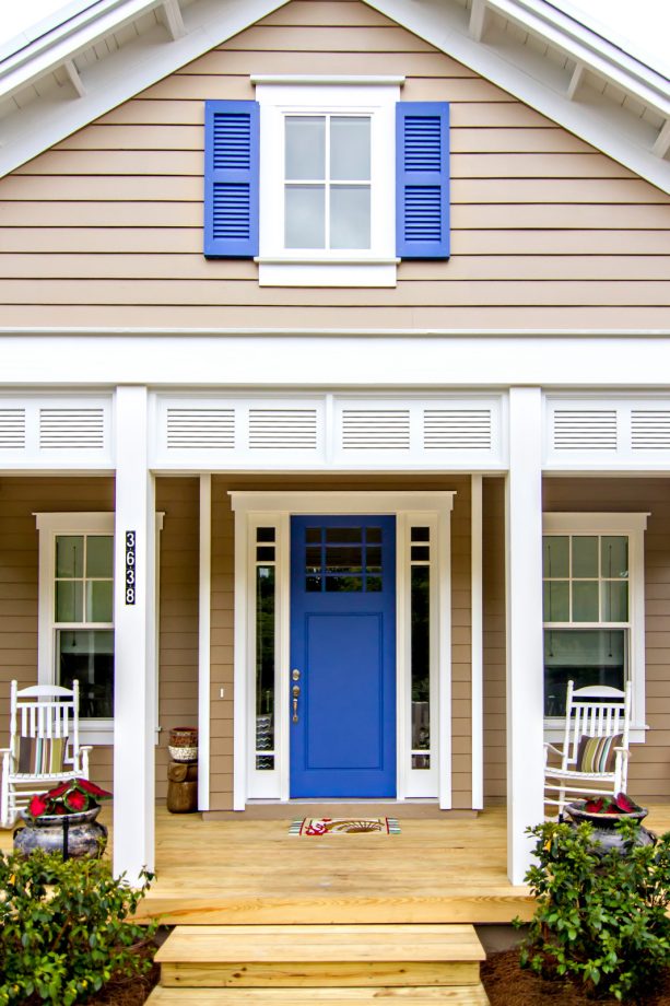 a beach style house that combines a sherwin williams sanderling #7513 main body and sherwin williams lupine #6810 navy blue shutters