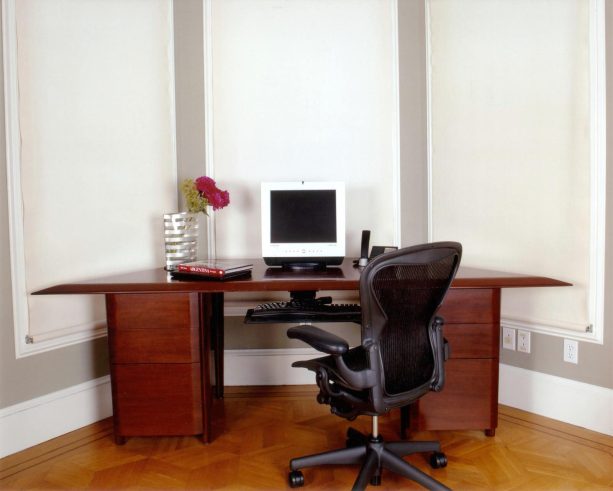 a custom mahogany desk with waterfall edges is a nice furniture piece to offer to a bay window