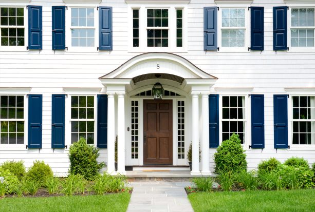 a large number of navy blue shutters combined with a bright white siding and a vinyl gable roof