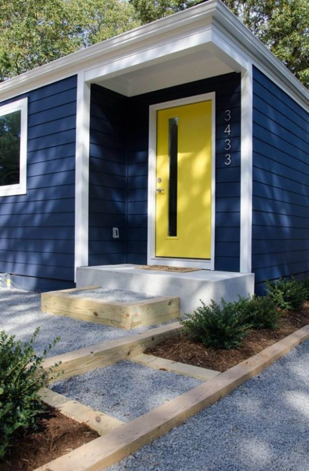 a midcentury wood exterior shingle roof house with a sherwin williams federal blue siding and a sherwin williams confident yellow door