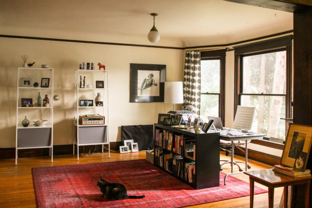 a modern black top desk with silver metal legs looks good in an eclectic home office with a bay window