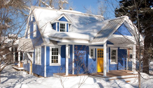 a renovated mid-sized timeless gable roof blue house with a yellow door painted in special custom colors