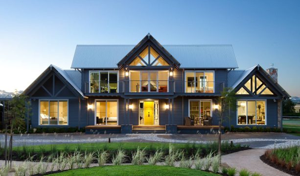 a super large traditional gable roof navy blue house with a yellow door and white trims all over