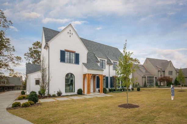 a tall gray shingle roof traditional home with a white wall and sherwin williams naval #6244 navy blue shutters