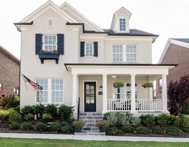 a timeless craftsman's traditional exterior boasts small navy blue shutters and ivory walls
