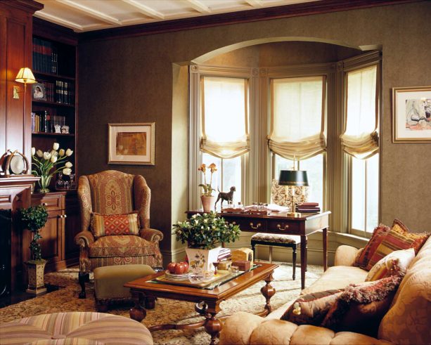 a traditional bay window with ecru linen blinds deserves to have a dark brown wooden desk on a beige carpet