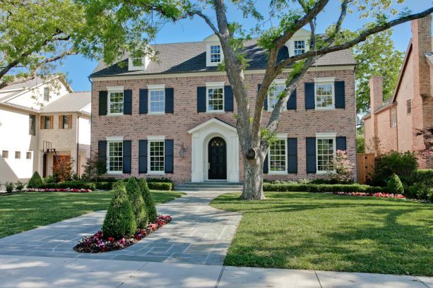 a traditional exterior with navy blue shutters and college blend antique bricks topped off by charcoal shingles