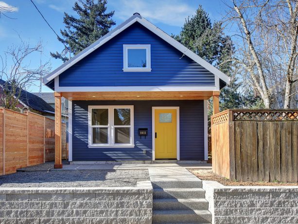 a traditional one-story wood exterior navy blue house with a wood exterior and a yellow door