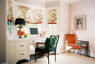 a white built-in wooden bay window desk paired with a black study chair