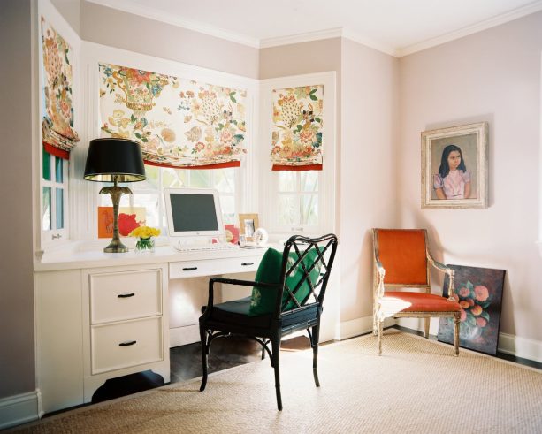 a white built-in wooden bay window desk paired with a black study chair