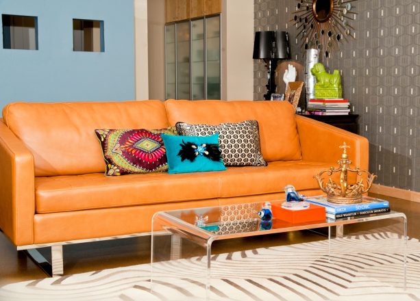 it is when a huge orange sofa meets a grey wallpaper that a modern living room finds its true soul