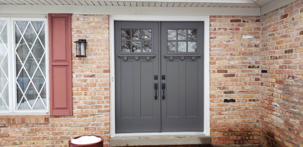 it is when front doors are painted in tuxedo grey combined with exposed brick walls and copper shutters that an entryway gets a gorgeous glow-up