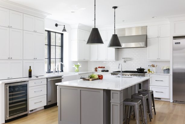 large white cabinetry and a dura supreme zinc gray island cabinet in a farmhouse kitchen can benefit from the addition of black pendants to the mix