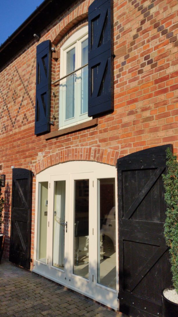 navy blue shutters that match a classic exterior with red and brown raw bricks