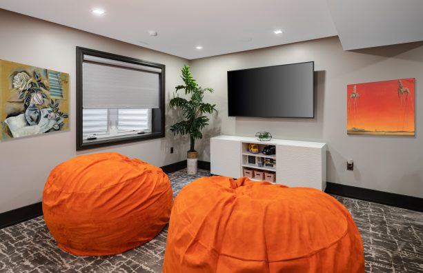 such a trendy living room a pair of big orange bean bags and grey walls and carpet can create