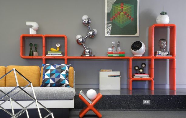 the pairing of a gray wall and orange modular shelving represents the true definition of color couple goals