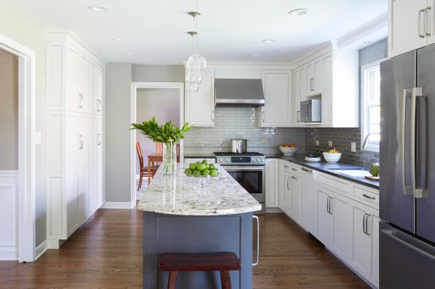 the presence of floor to ceiling white cabinetry has an intense aura in a kitchen with a dark gray island cabinet and wall mounted cabinets