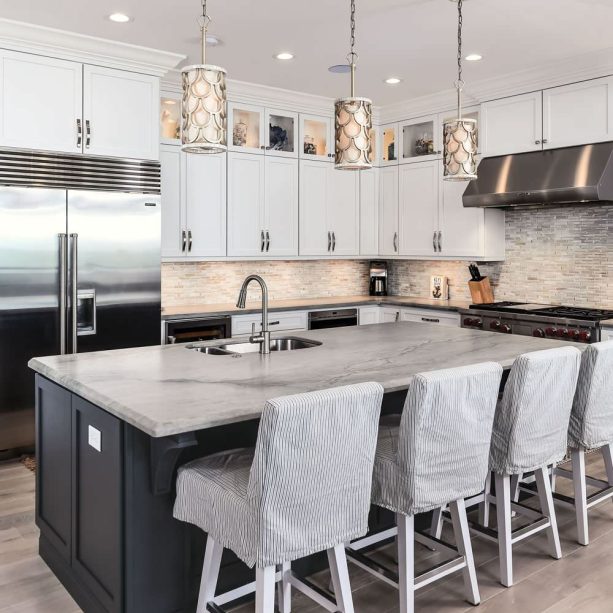 what a range of white wall cabinets and a super dark island shaker cabinet offers in a kitchen with a gray backsplash is beauty in simplicity