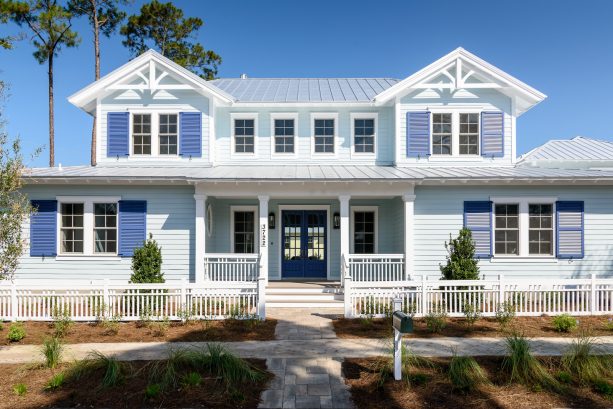when sherwin williams luxe blue navy shutters are paired with sherwin williams tradewind lap siding to beautify a coastal home