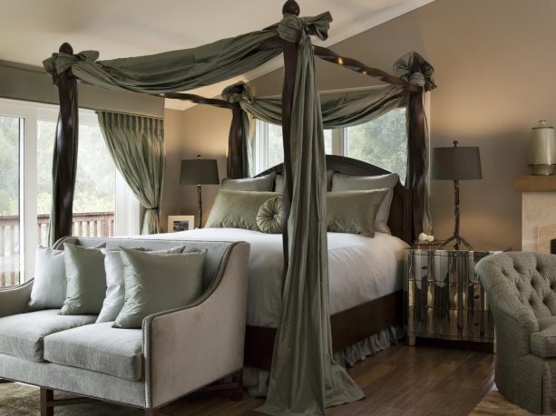 a bed with grey drapes ensures privacy in a brown bedroom