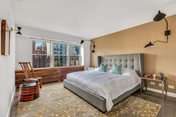 a bedroom with brown cabinetry and a grey bed that boasts a peculiar look