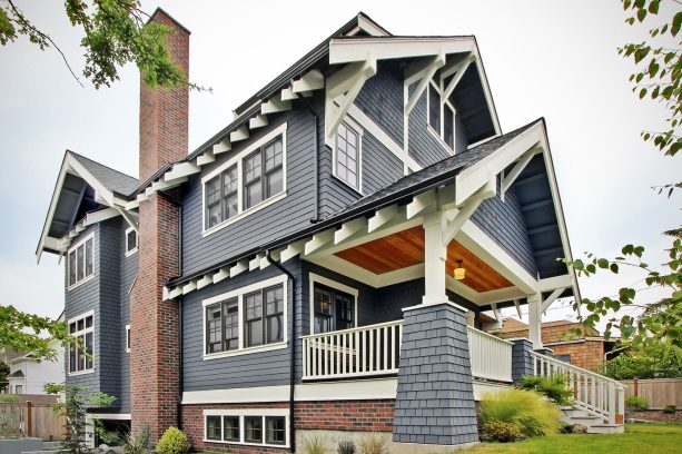 a craftsman house greatly appreciates a dark gray wooden gable front porch