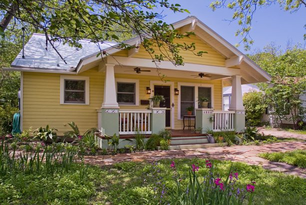 a gable front porch painted in a color similar to benjamin moore’s hawthorne yellow