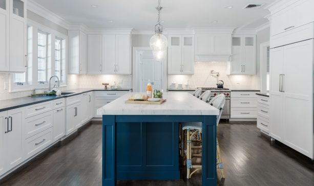 a kitchen that houses a benjamin moore hale navy island and white wall cabinets