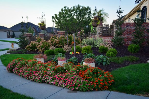 a landscaping idea that incorporates lots of flowers and mini trees into a corner lot isn’t one to be made fun of