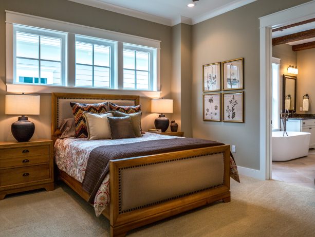 a light brown wooden bed in a bedroom with sherwin williams’ loggia grey walls