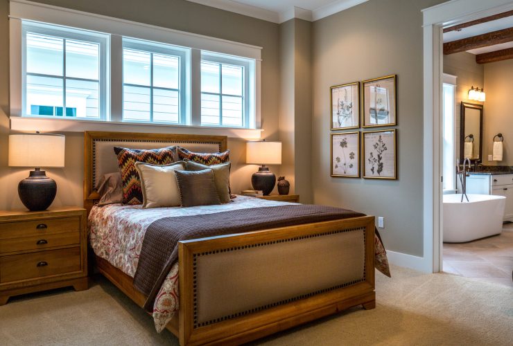 a light brown wooden bed in a bedroom with sherwin williams’ loggia grey walls