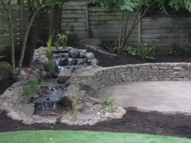 a rip rap retaining wall is a brilliant addition to a backyard with a water feature