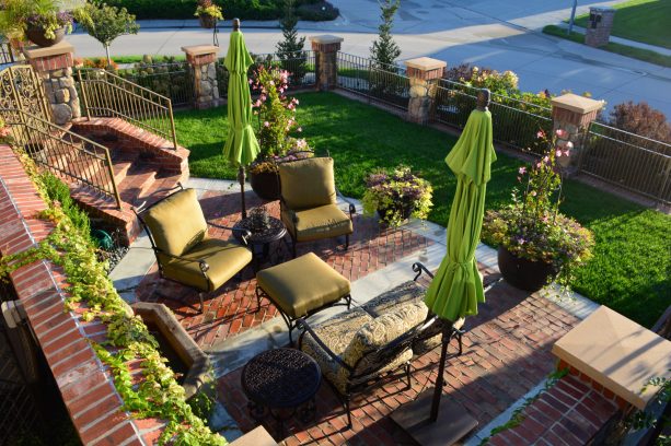 an idea that sees a corner lot landscaped into a large seating area with sunbrella