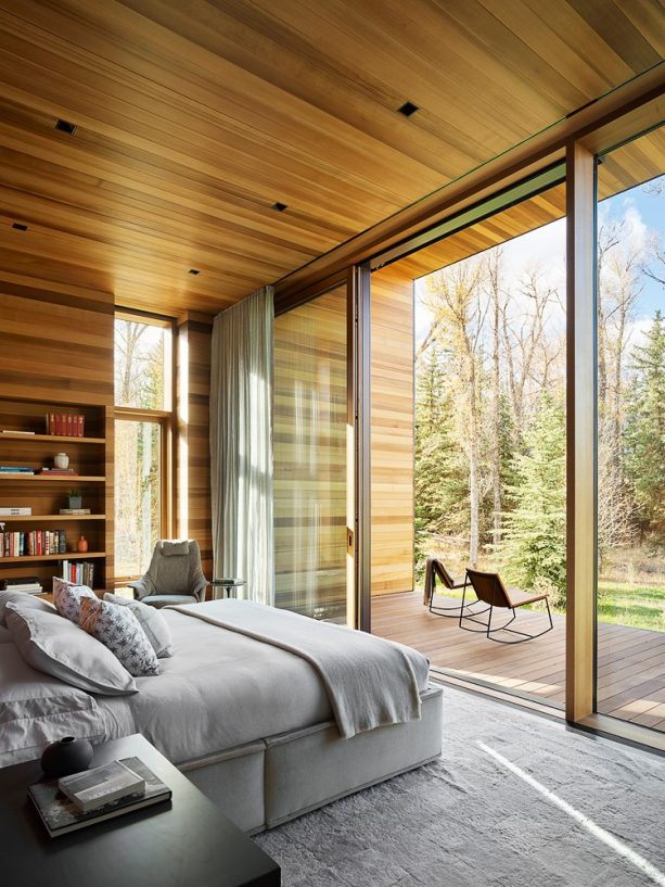 brown wall shelves and a big grey bed comfortably exist in a bedroom that welcomes the surroundings