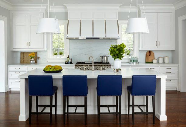 countertop stools with navy upholstery are perfect additions to an almost all-white kitchen