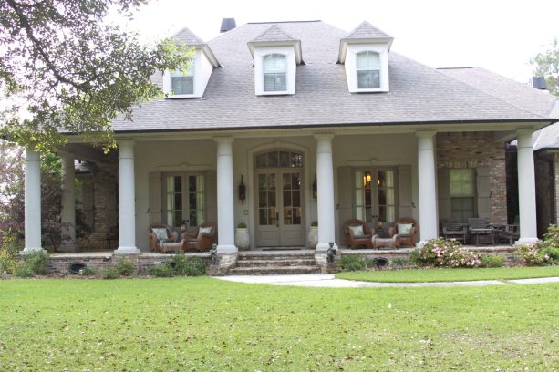 gray french colonial front door in a bright white exterior