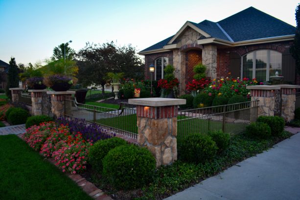 mediterranean corner lot landscaping idea with stone fence posts
