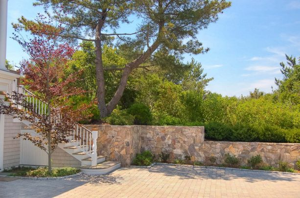 traditional style stone veneer retaining wall combined with concrete paver driveway