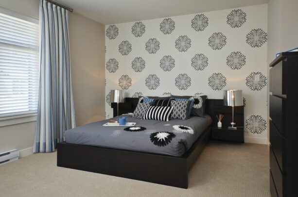 a beige bedroom benefits a lot from the addition of a white accent wall with custom wallpaper