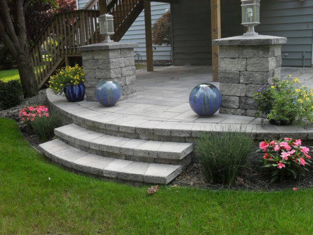 a concrete raised paver patio with stairs and no covers offers durability and longevity